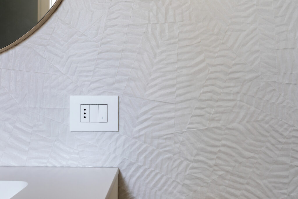 dettaglio parete bagno con piastrelle 3d bianche effetto carta