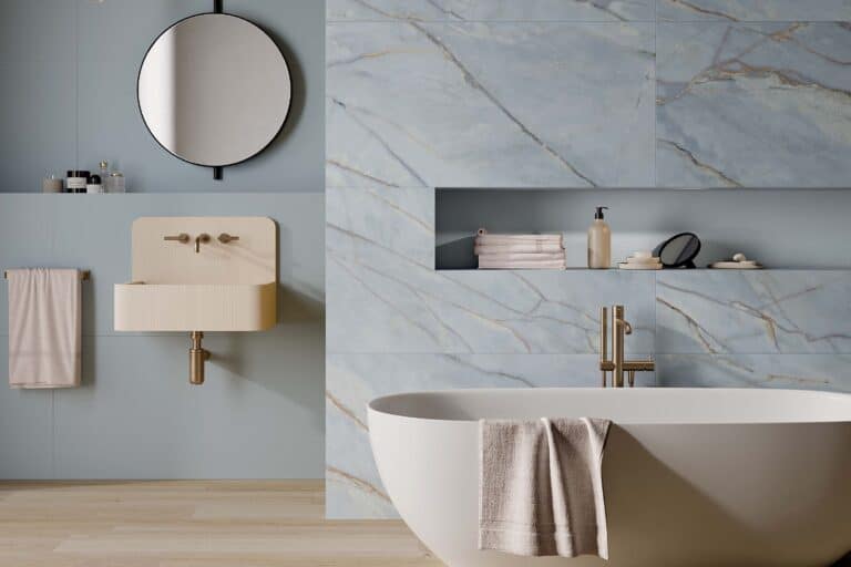 parete bagno con piastrelle gres effetto marmo azzurre e pavimento effetto legno