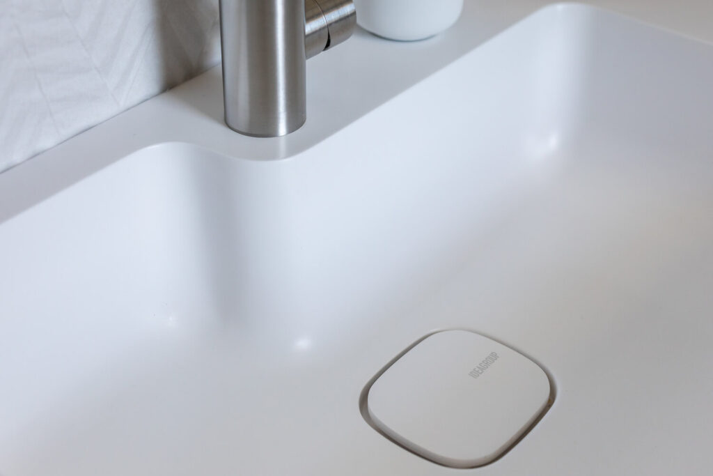 dettaglio lavabo bagno in solid surface con piletta coordinata