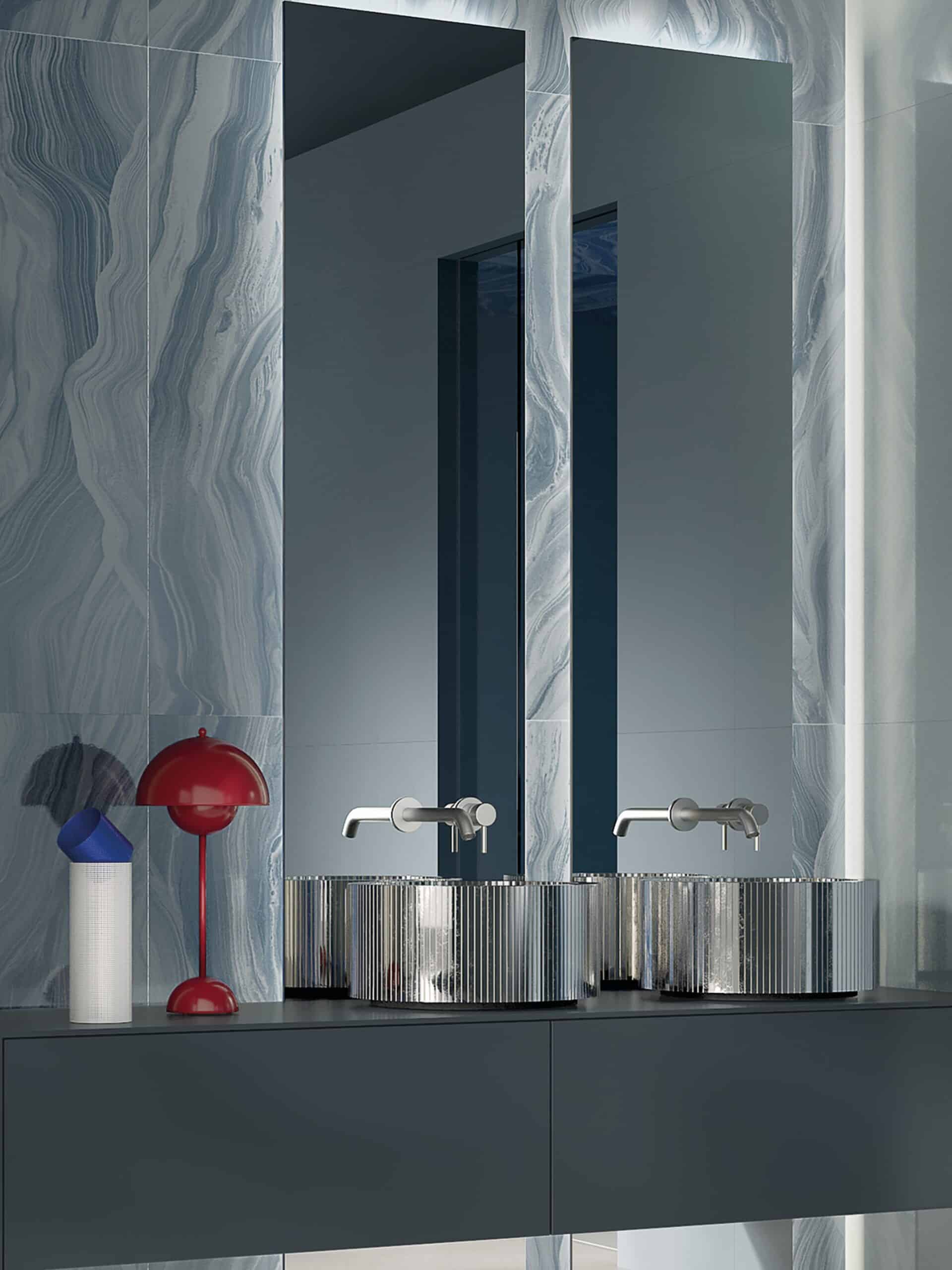 Dettaglio parete bagno con piastrelle effetto marmo azzurro a parete e gres porcellanato a specchio
